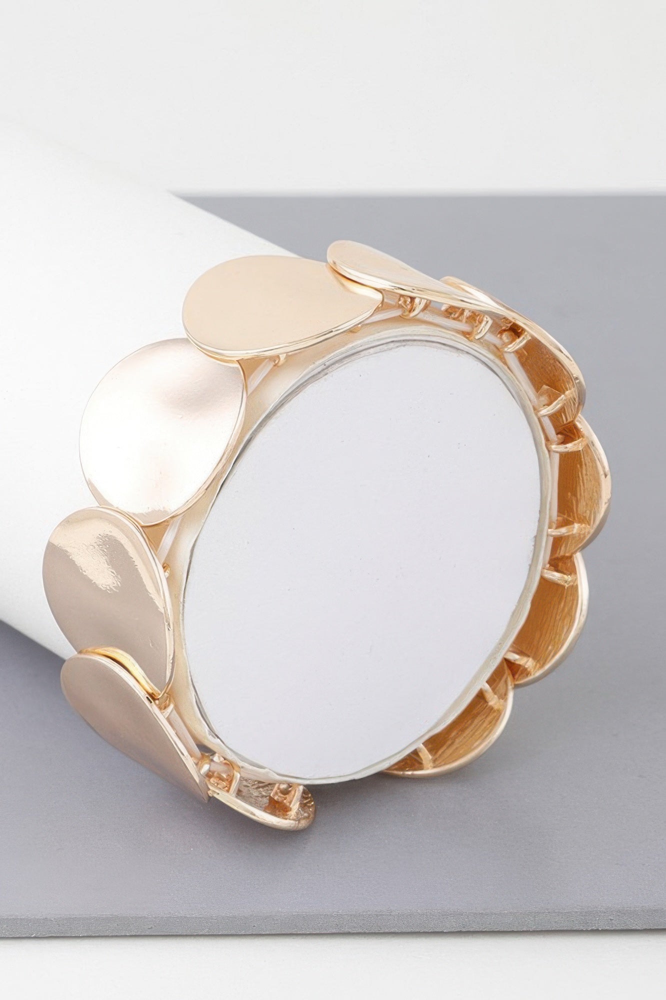 Gold shiny flat disc plate bracelet with oval plates and linked cuff, angled view