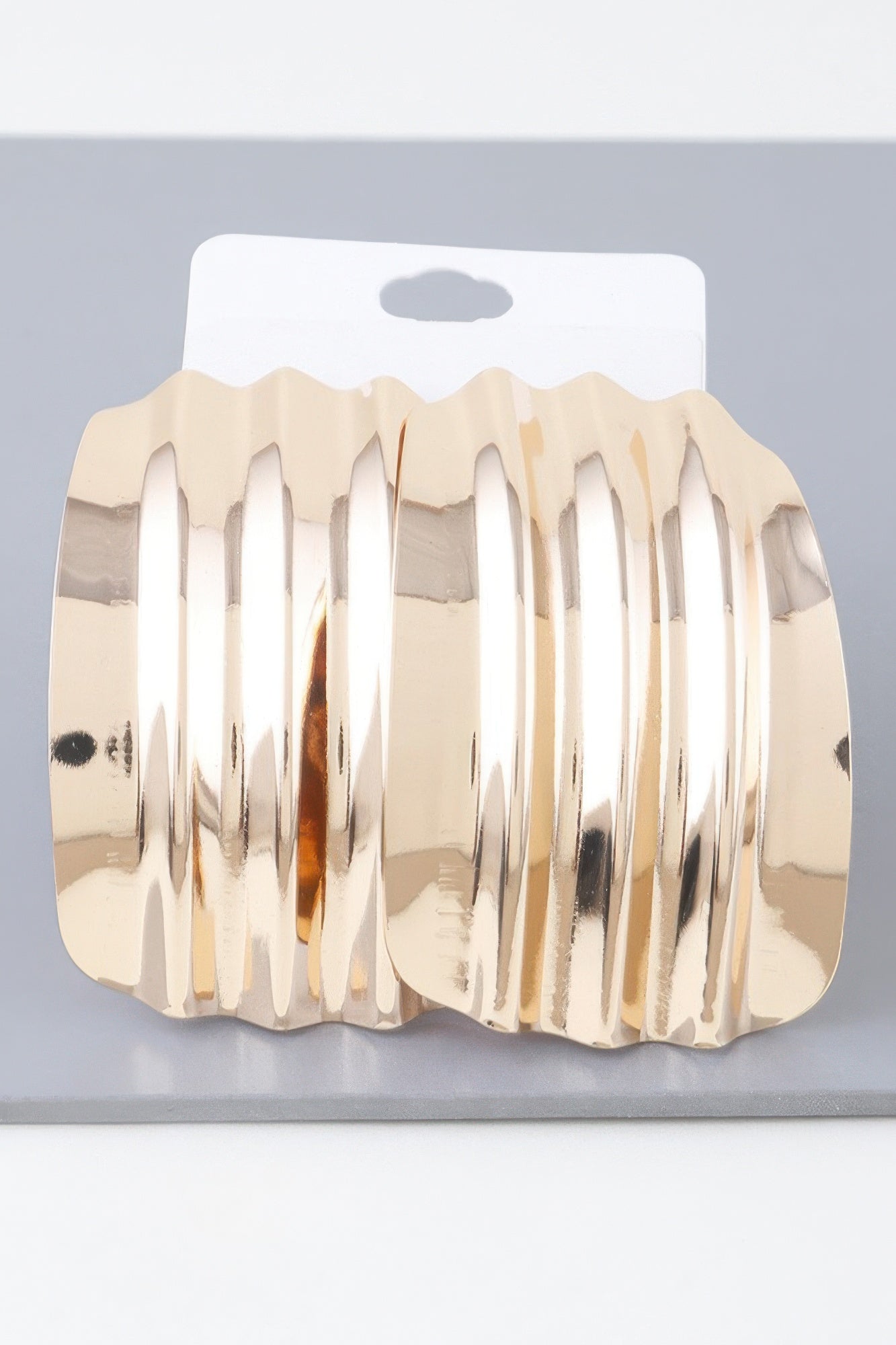 Shiny ribbed curve hoop earrings in gold tone, scalloped edge and ridged texture
