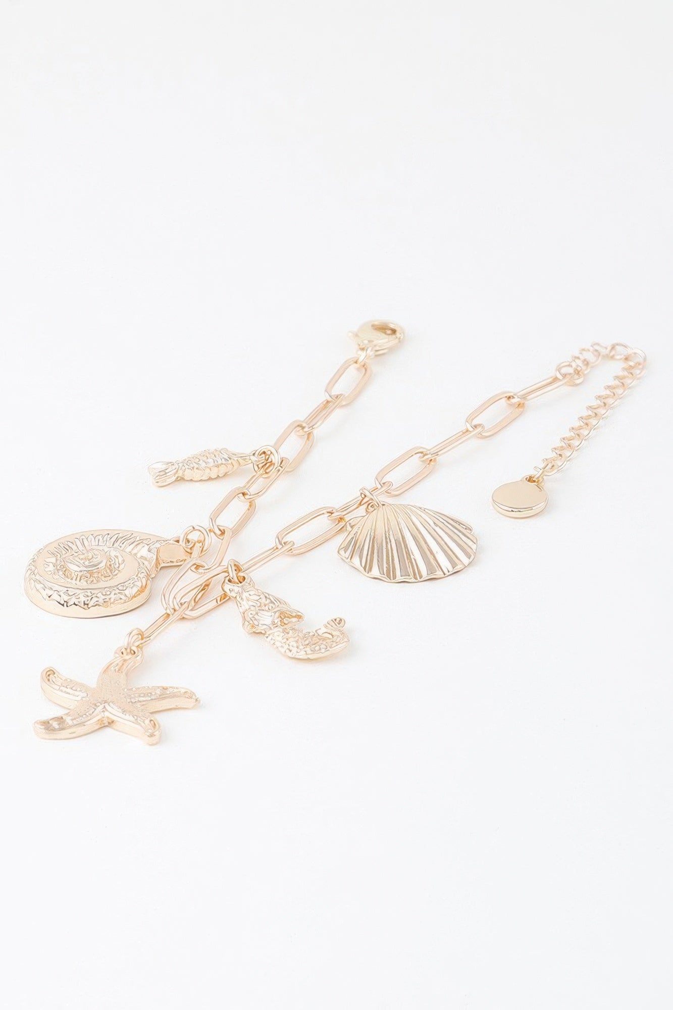 Gold-tone linked bracelet with seashell medallion and dangling starfish and fin charms