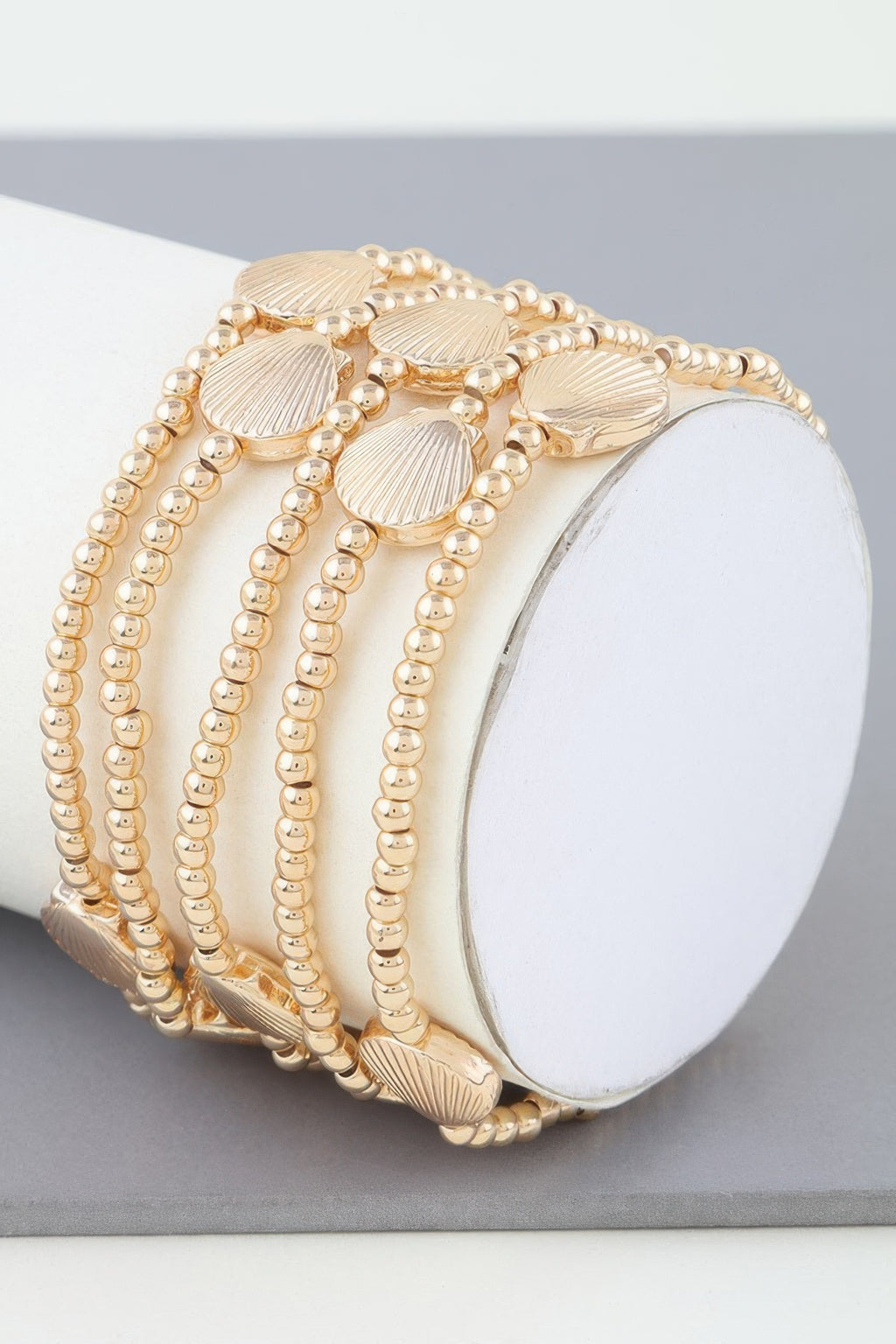 Shiny seashell beaded bracelet in gold tone with ridged shell charms