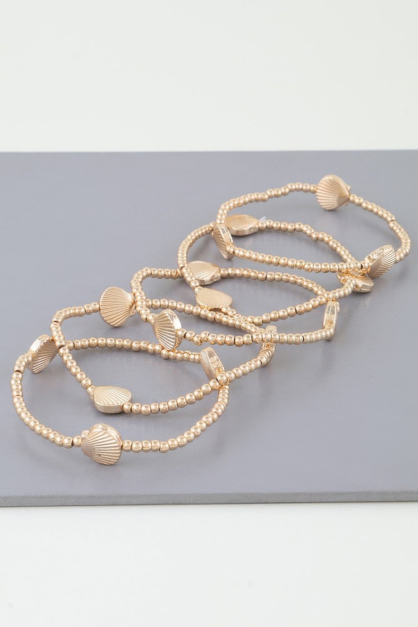 Gold seashell beaded bracelet with several bead strands and shell-shaped spacers