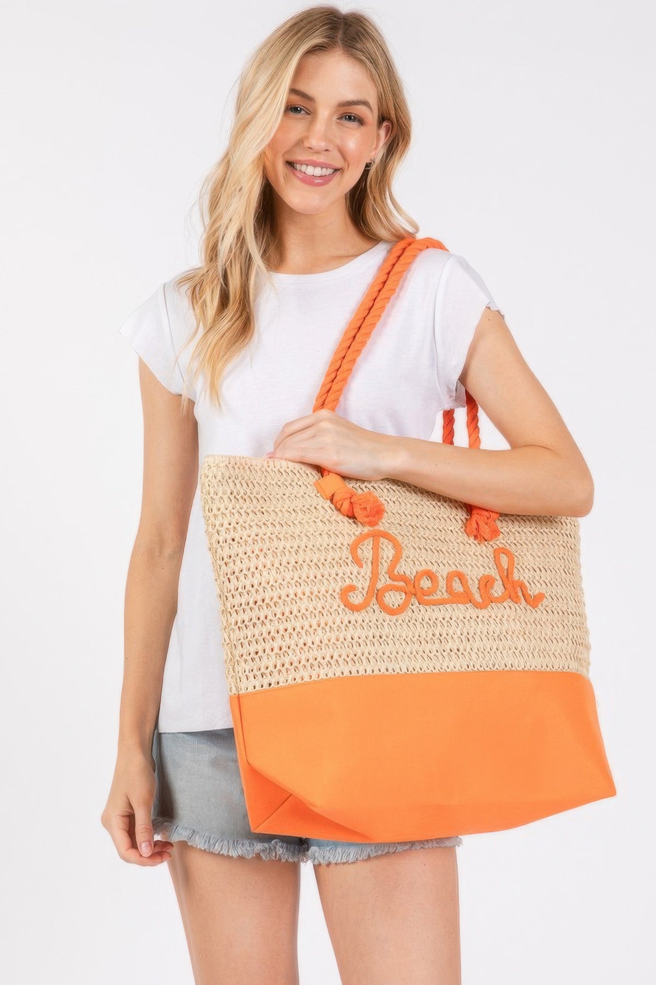 Crochet beach tote, beige knit with orange bottom, rope straps and “Beach” logo