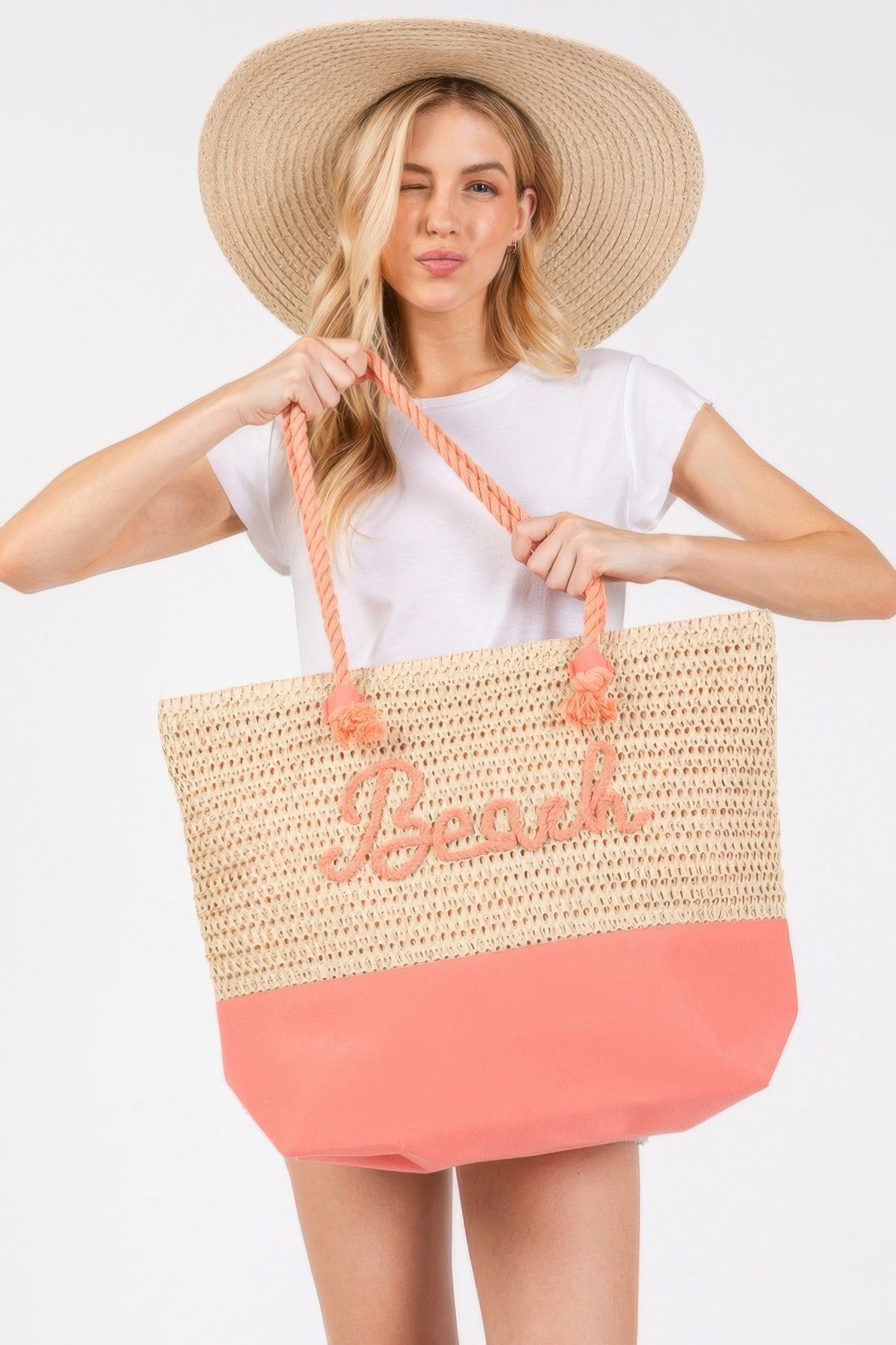 Crochet beach tote, beige crochet with coral-pink bottom, rope handles with pom accents, “Beach”