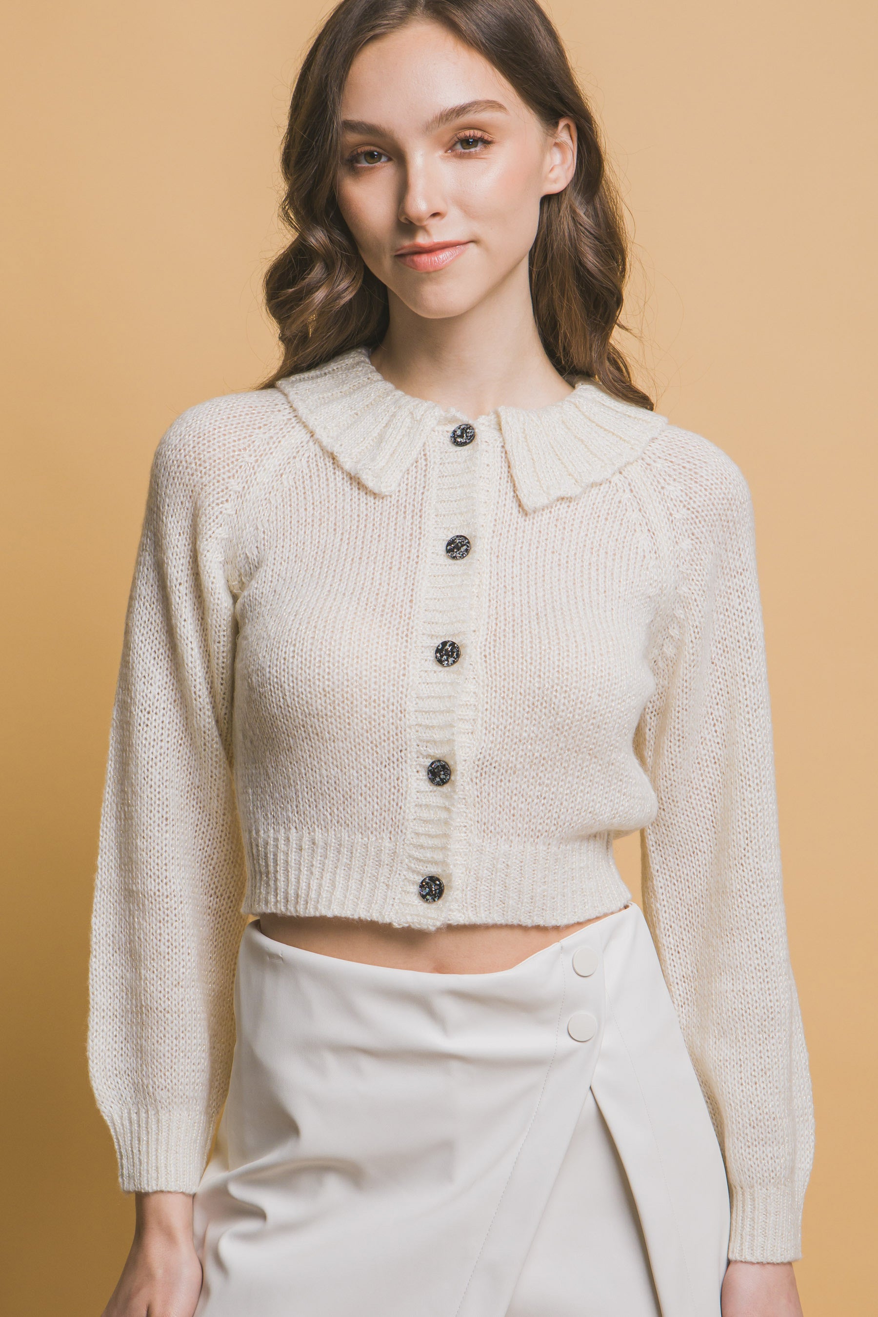 Short collared sweater in off-white knit with button front and ribbed cuffs