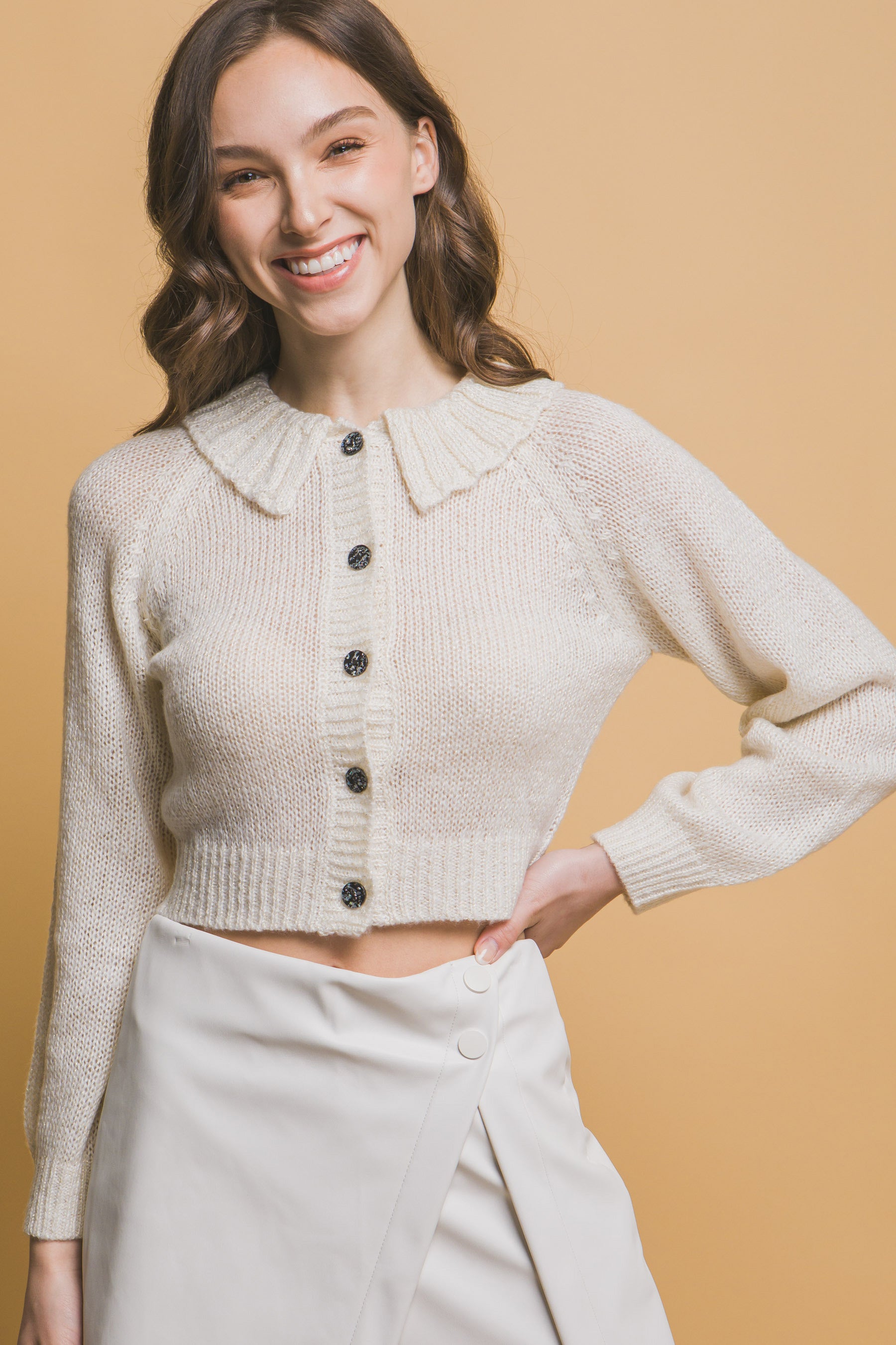 Off-white short collared knit sweater with buttoned front and wide collar