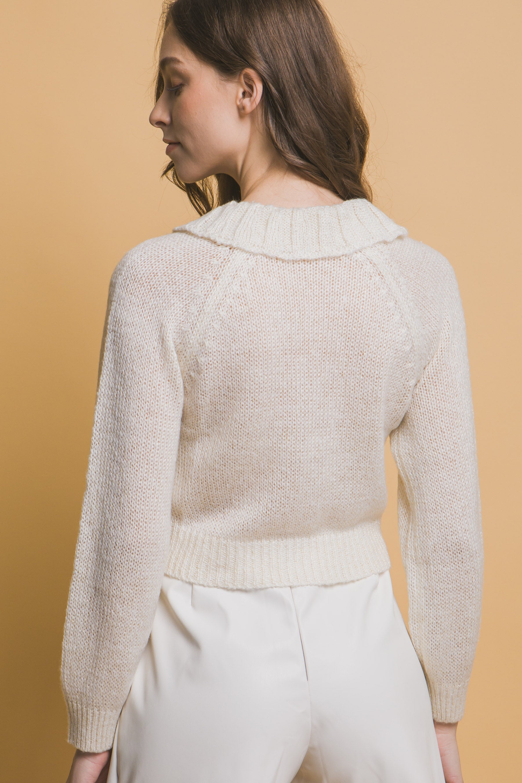 Off-white short sweater, round back with ribbed waistband and long sleeves