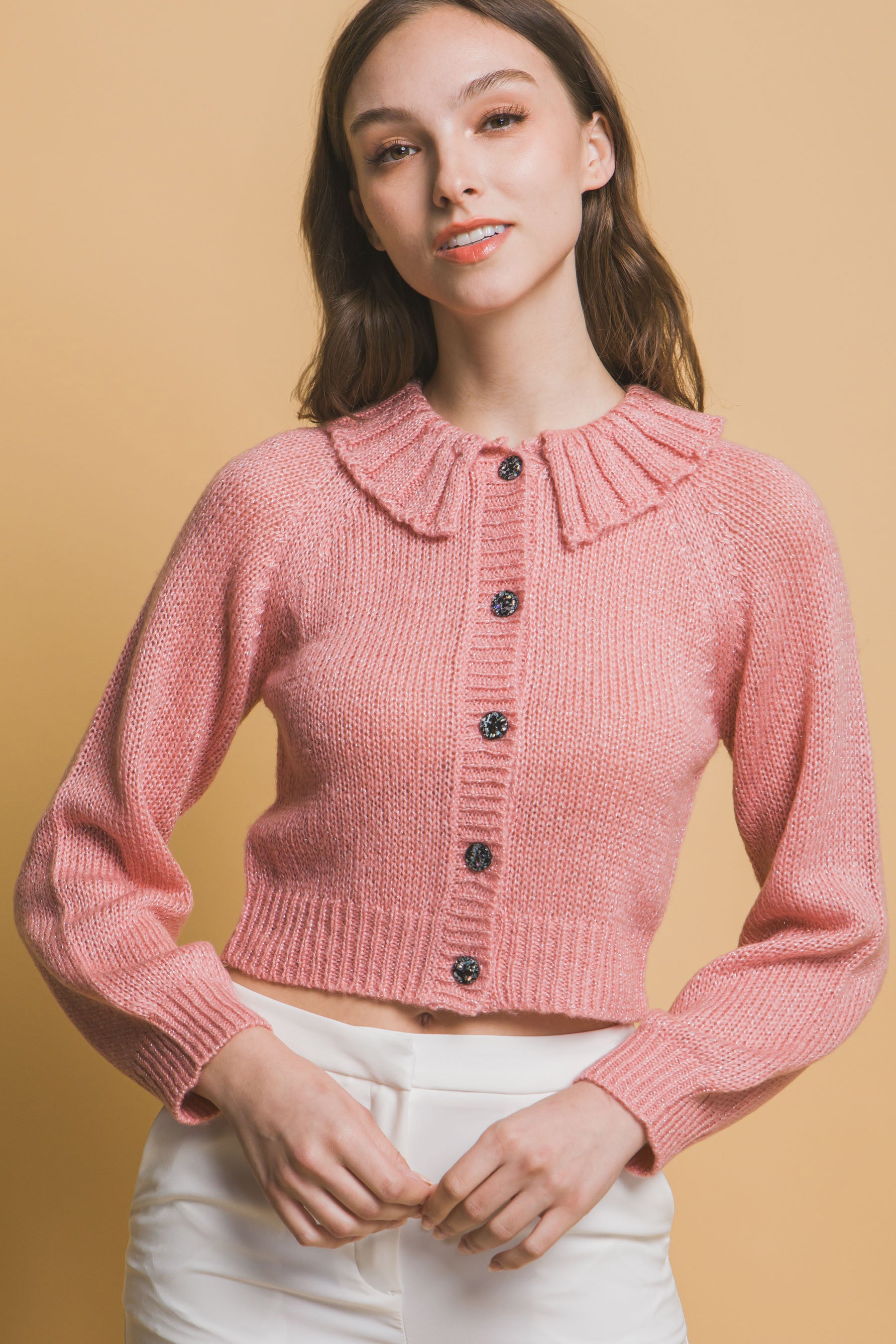 Pink cropped knit sweater detail: high collar and dark buttons down center