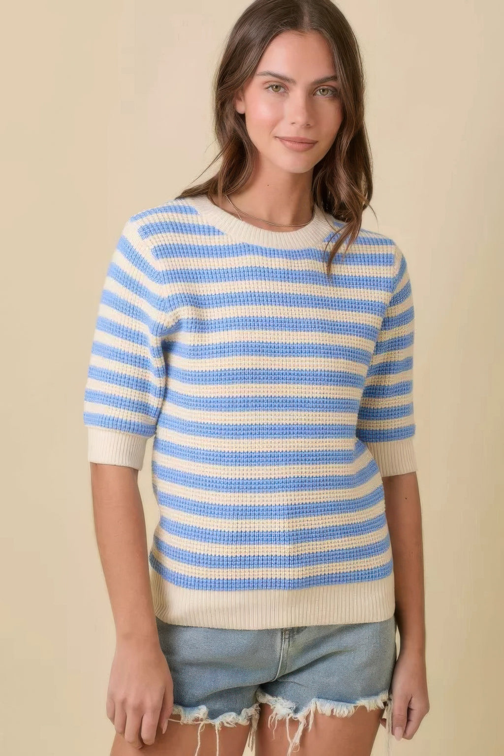 Cream and blue striped knit sweater with crew neckline and ribbed cuffs