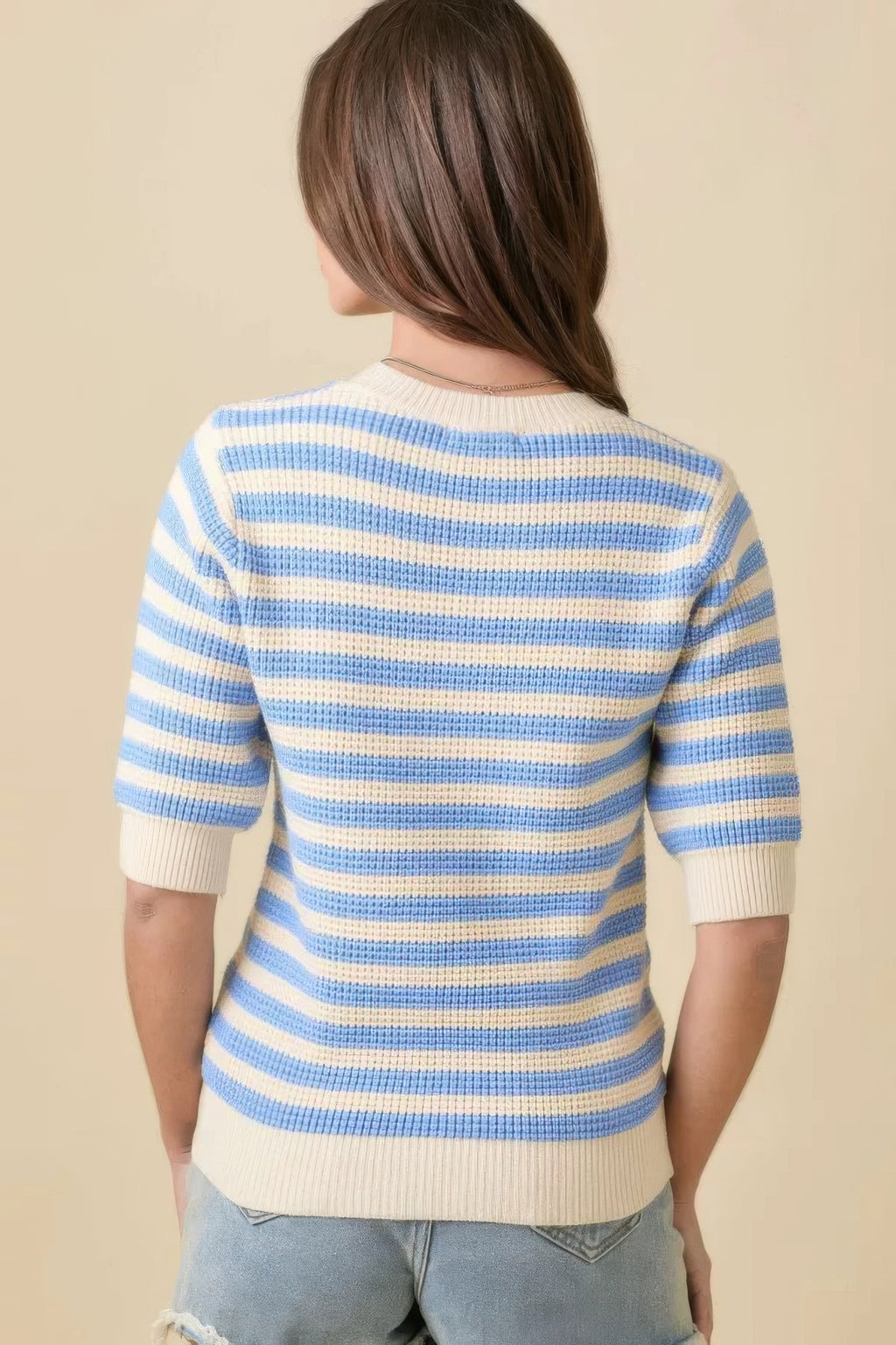 Back view of cream-and-blue striped knit sweater top, short sleeves, ribbed hem
