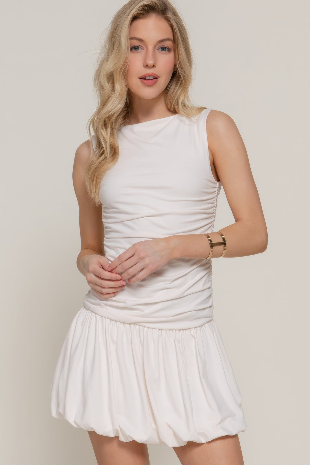 Ivory sleeveless boat neck voluminous mini dress with ruched bodice and pleated skirt
