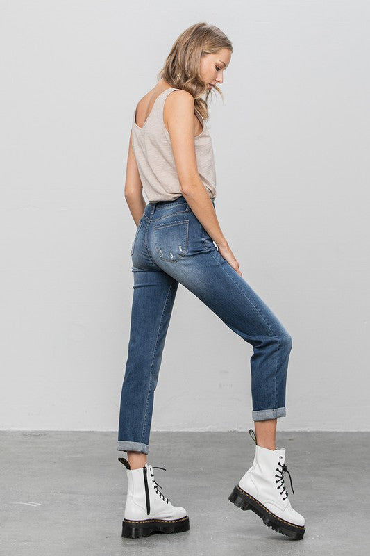 Dark slim boyfriend jeans, side view with front pocket stitching and cuffed ankle hem.