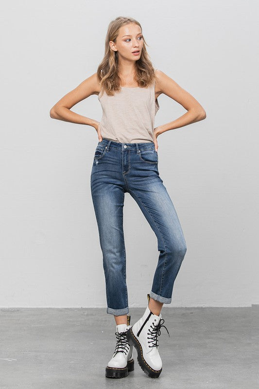Dark slim boyfriend jeans, 3/4 front view with mid-rise waist and cuffed ankle hem.