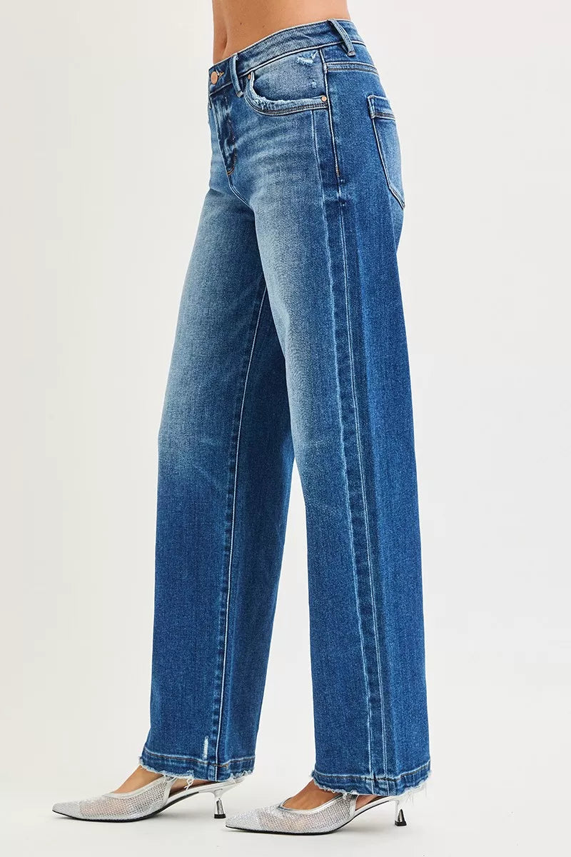 Side view of baggy blue jeans showing side seams and wide leg opening