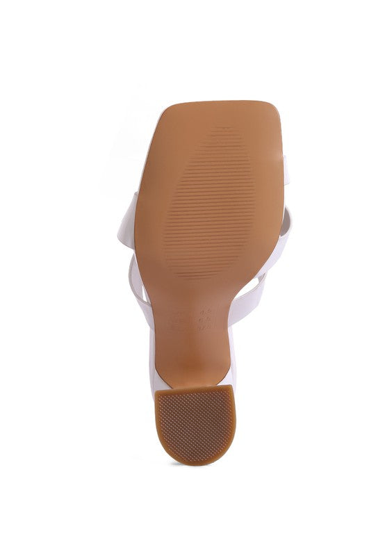 Underside view of white heeled sandal outsole with textured grip