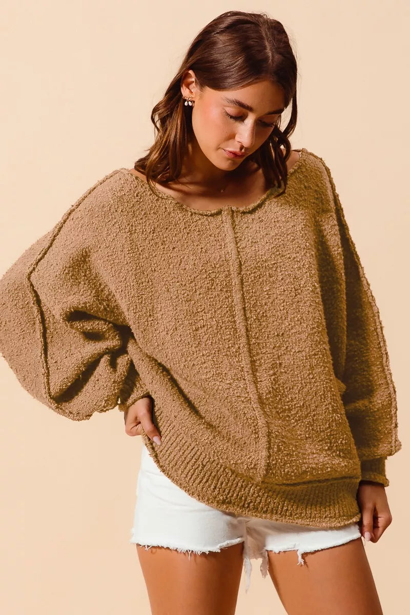 Taupe bouclé slouch sweater showing textured knit, exposed seam lines, ribbed cuffs