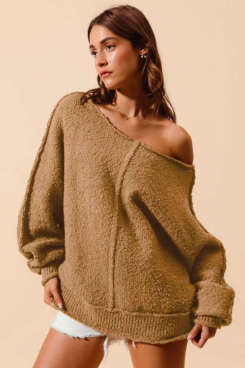 Taupe bouclé sweater with wide one-shoulder neckline, exposed center seam, ribbed bottom hem