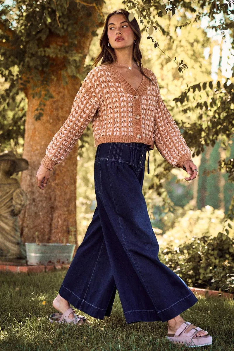 Camel textured knit cardigan with button front, V-neck and long sleeves over jeans
