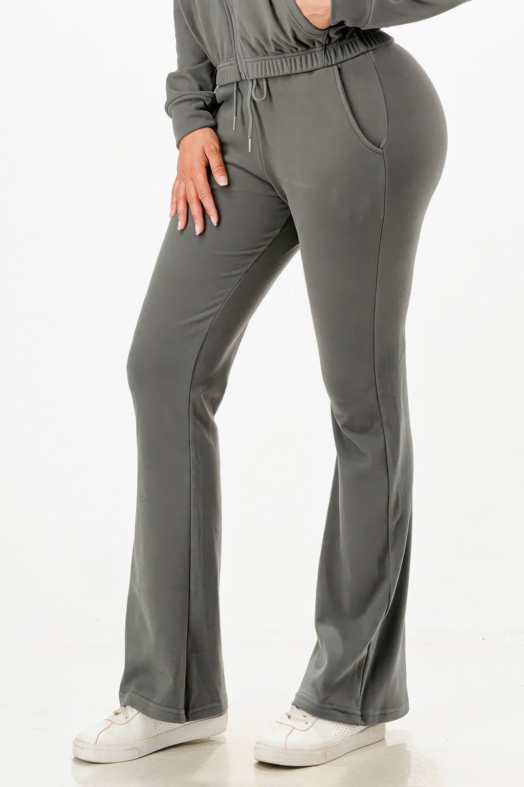 Gray track pants close-up: smooth front, elastic waist, drawstring, flared straight legs.