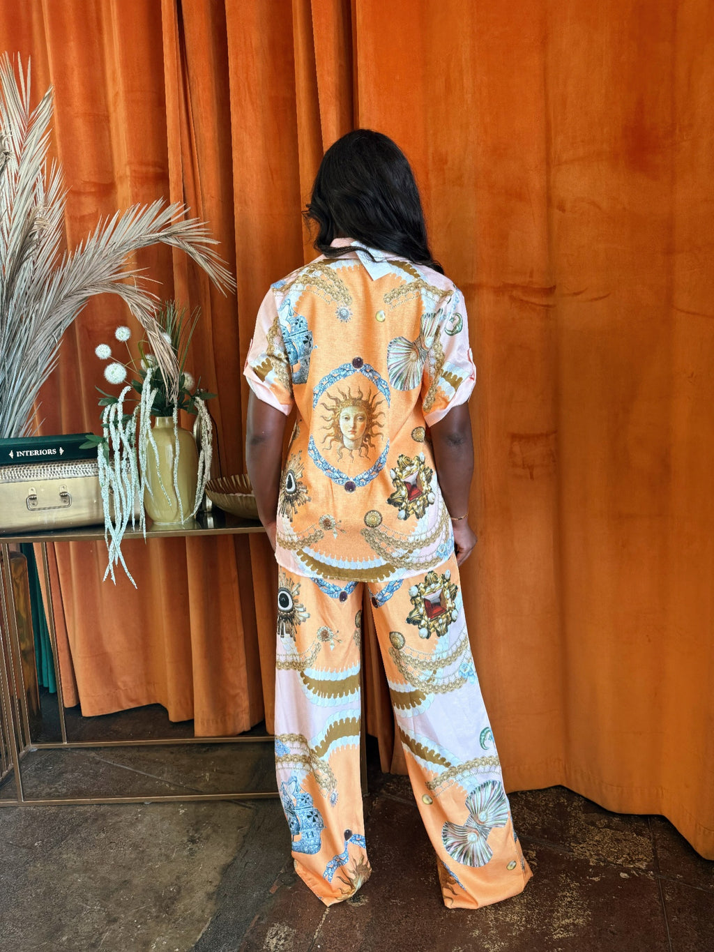 Solar Muse set: back view of orange-blue graphic print shirt and wide-leg pants