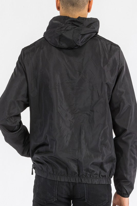 Black lightweight windbreaker jacket, back view, with adjustable hood and elastic hem.