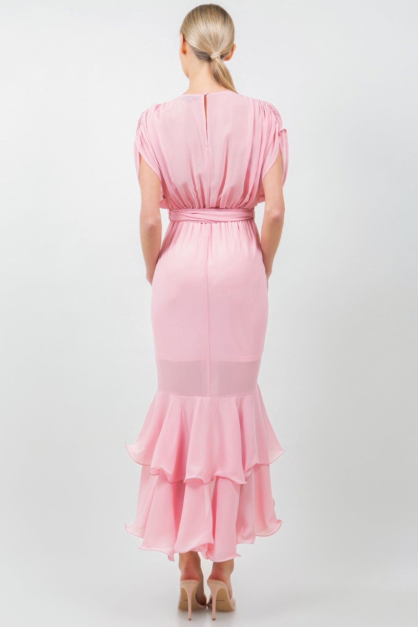 Back view of solid pink midi dress with tie waist and ruffled hem