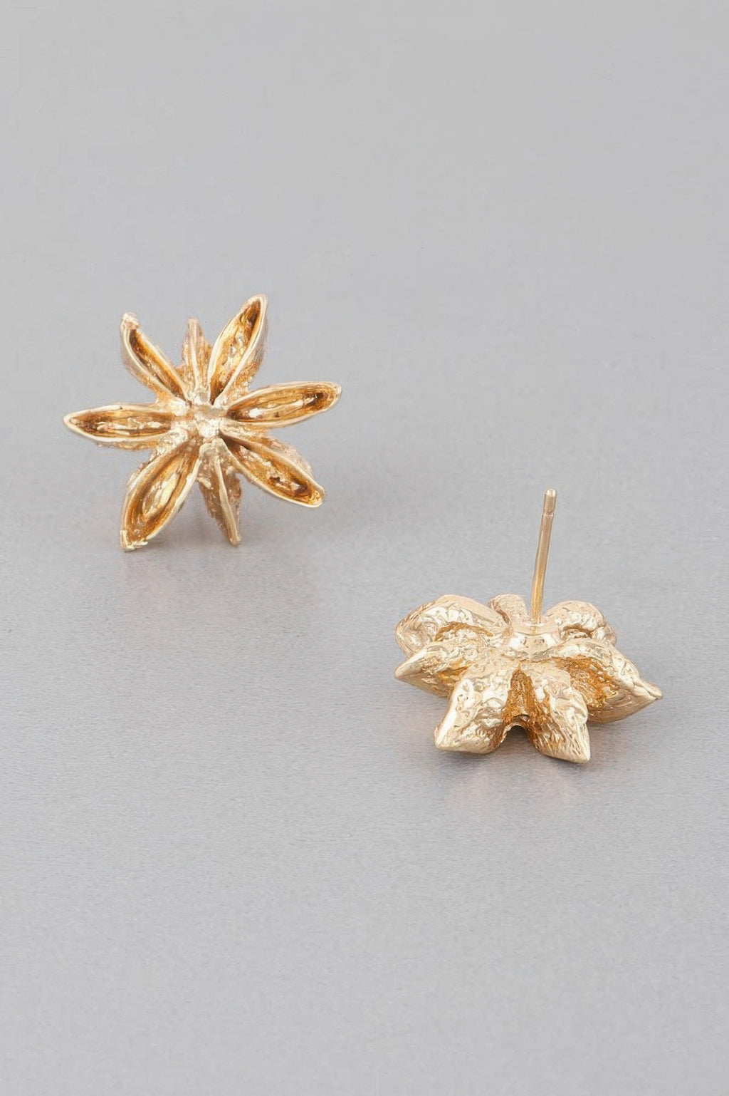 Gold five-petal spice flower studs with textured metallic finish
