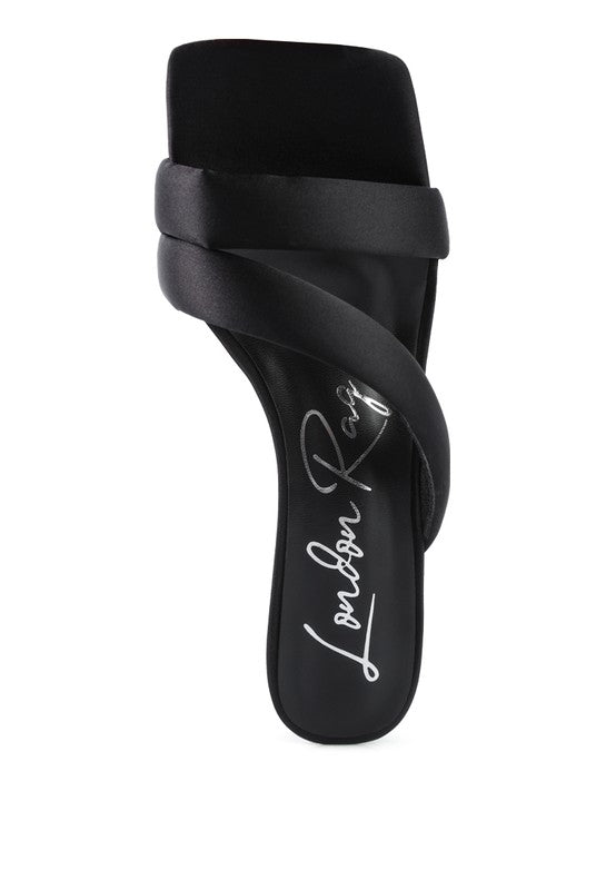 Black slide heels with sculpted strap over the foot and signed insole