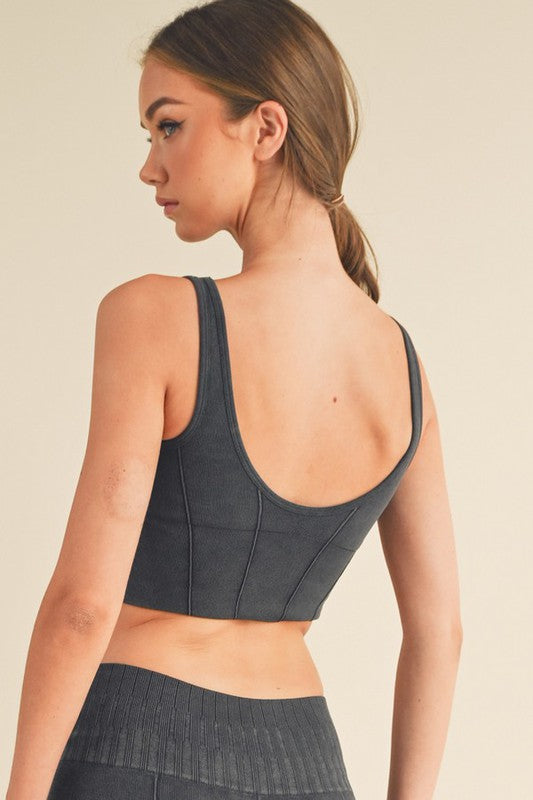 Back view: ribbed sports bra with wide straps and seamed panels, dark grey color.