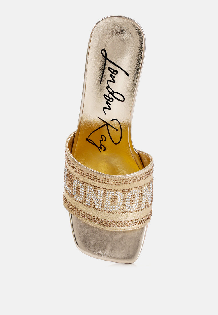 Gold mule sandals with rhinestone strap detail and square-toe opening