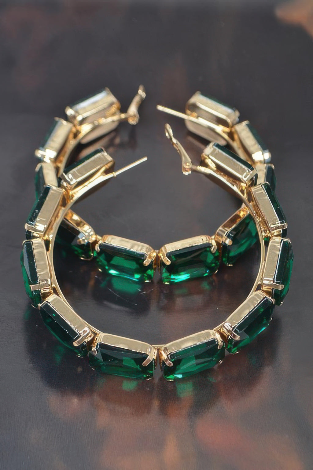 Green stone hoop earrings with gold-tone settings and hinge back