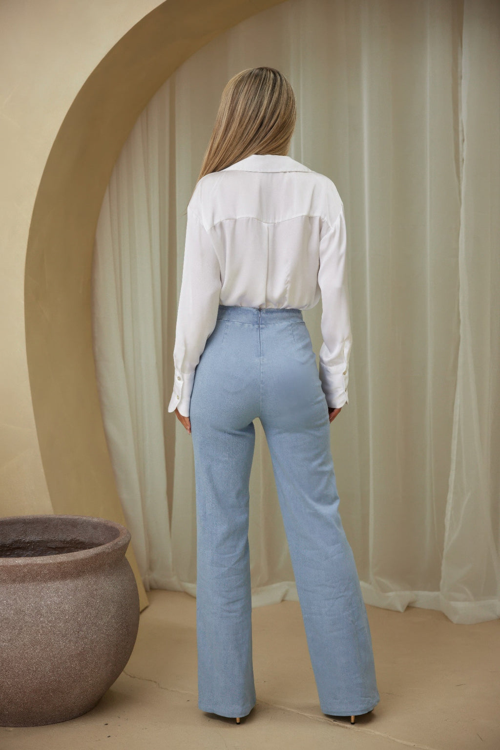 Back view of light blue wide-leg dress pants with belt and straight leg silhouette