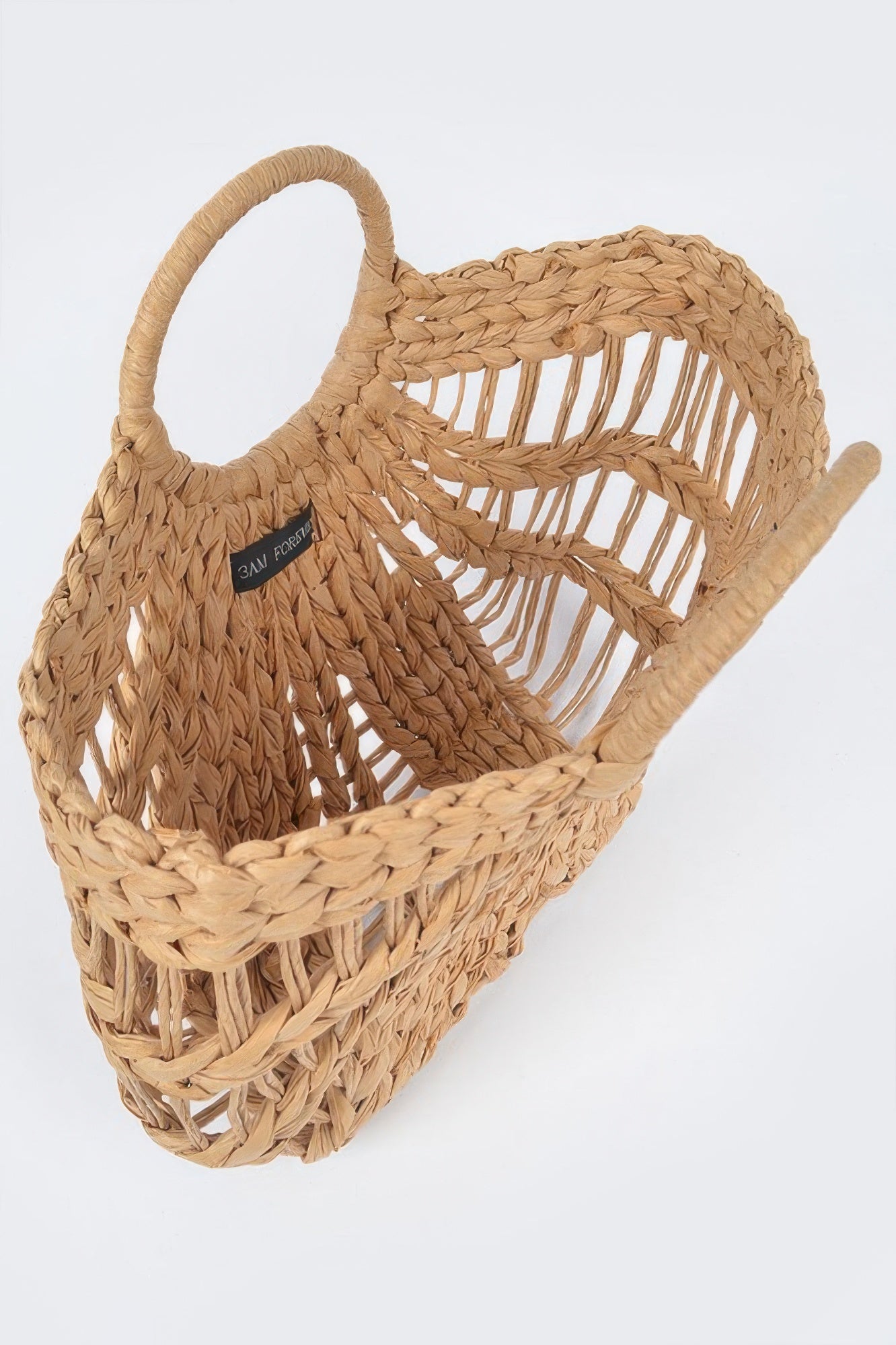 Khaki straw beach bag, close-up with leather tag and open slatted weave