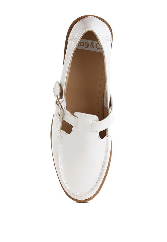White patent Mary Jane loafer interior and buckled strap detail, flat sole