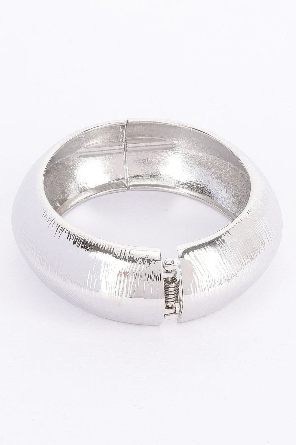 Silver textured metal bangle bracelet with hinge clasp and spring detail visible