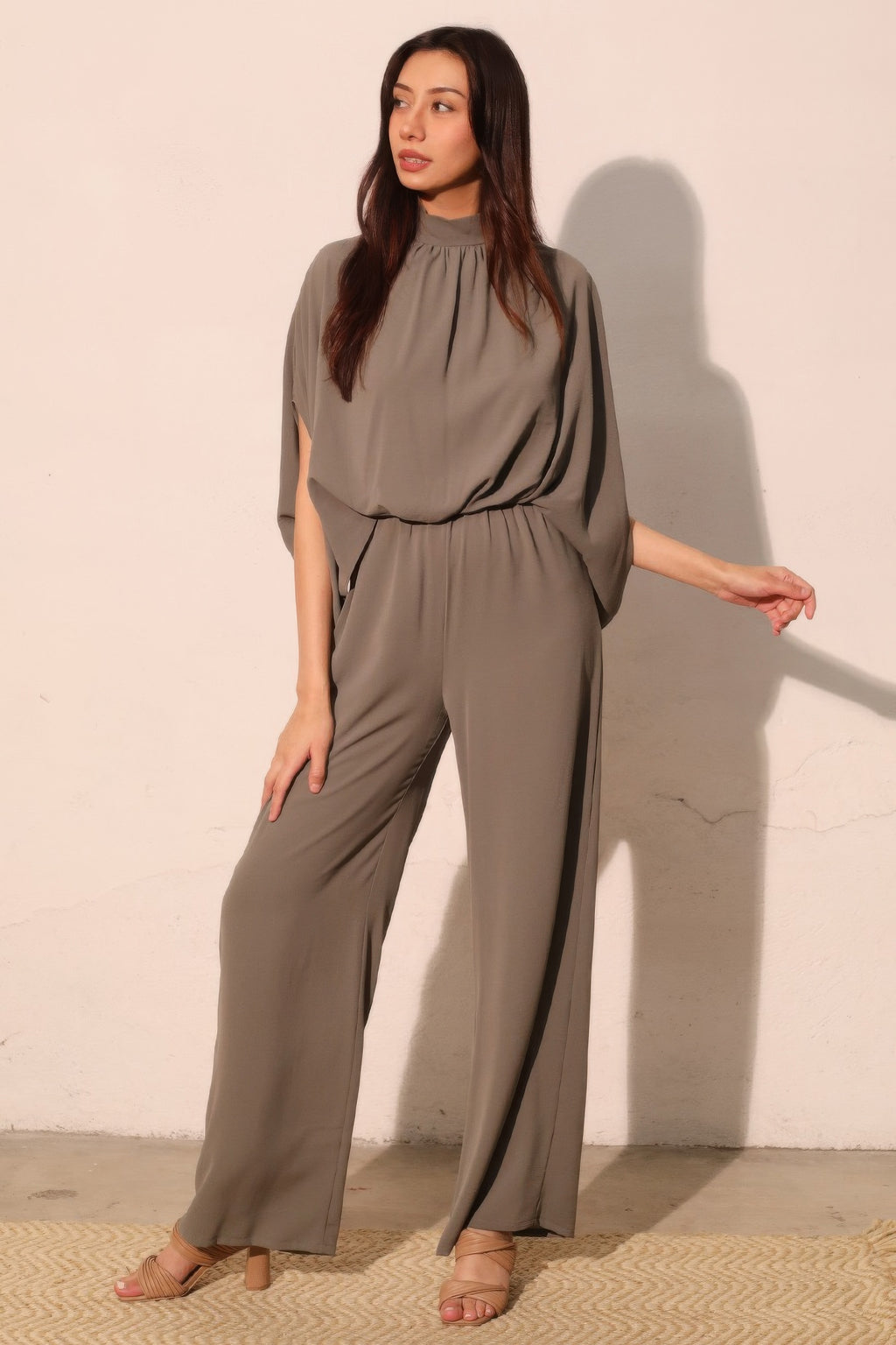 Gray mock neck caftan jumpsuit with draped wide legs and elastic waist