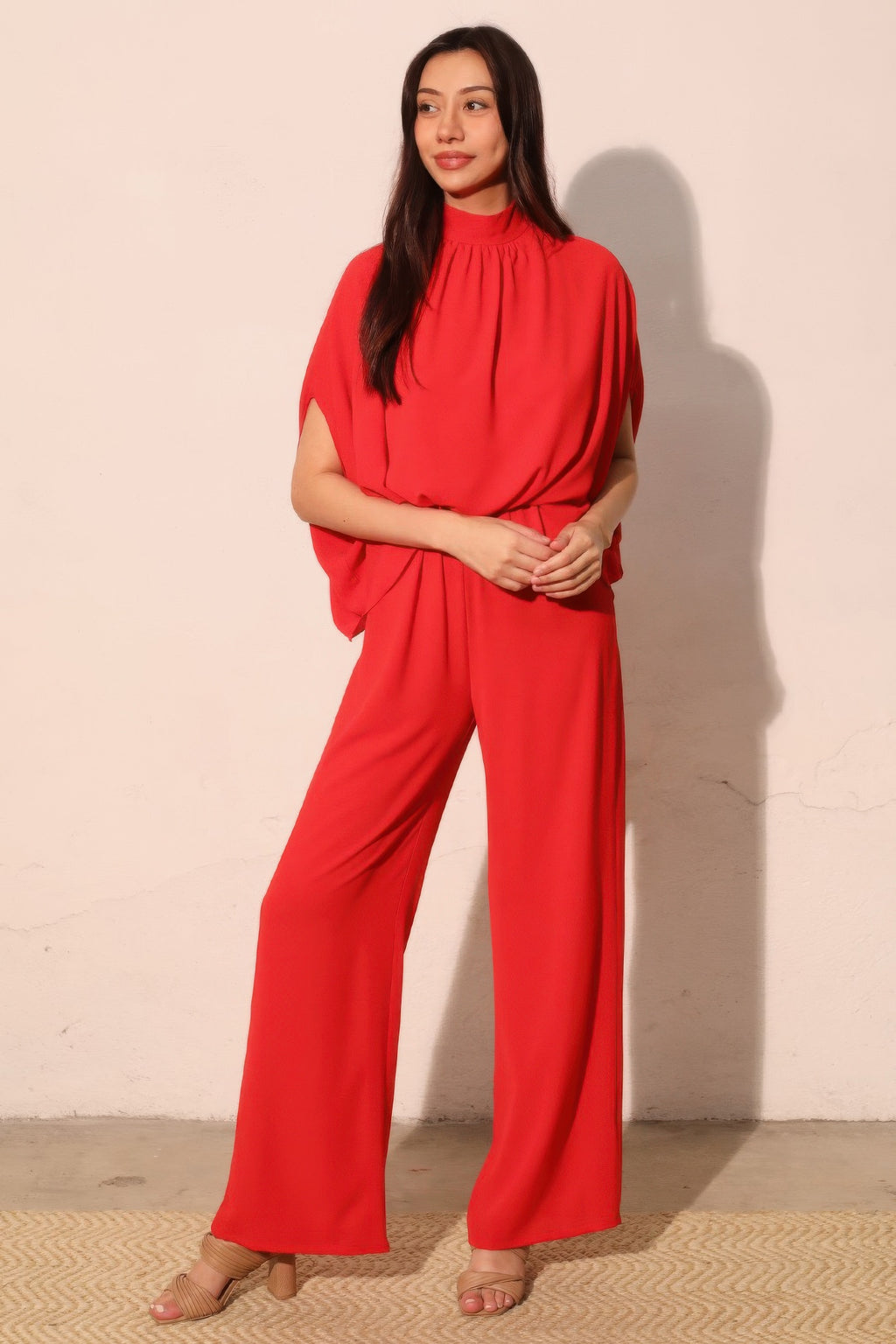 Red mock neck caftan jumpsuit, draped dolman sleeves and straight wide-leg fit