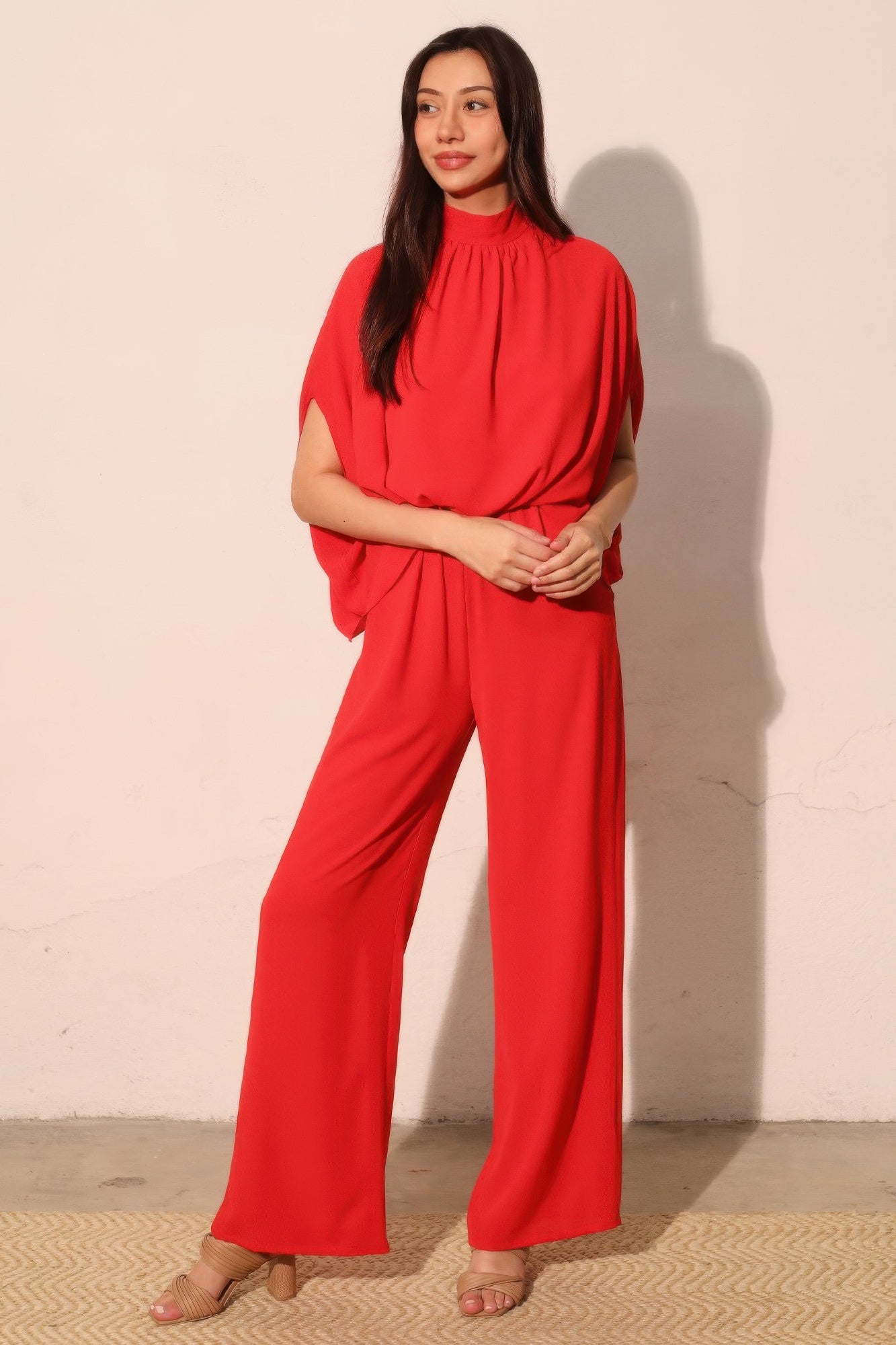 Red mock neck caftan jumpsuit, draped dolman sleeves and straight wide-leg fit