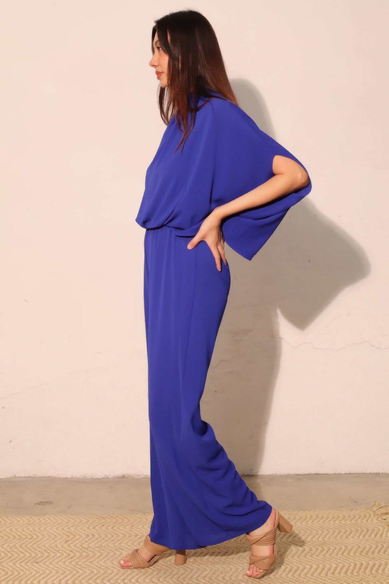 Royal blue mock-neck caftan jumpsuit with dolman sleeves and wide-leg silhouette.
