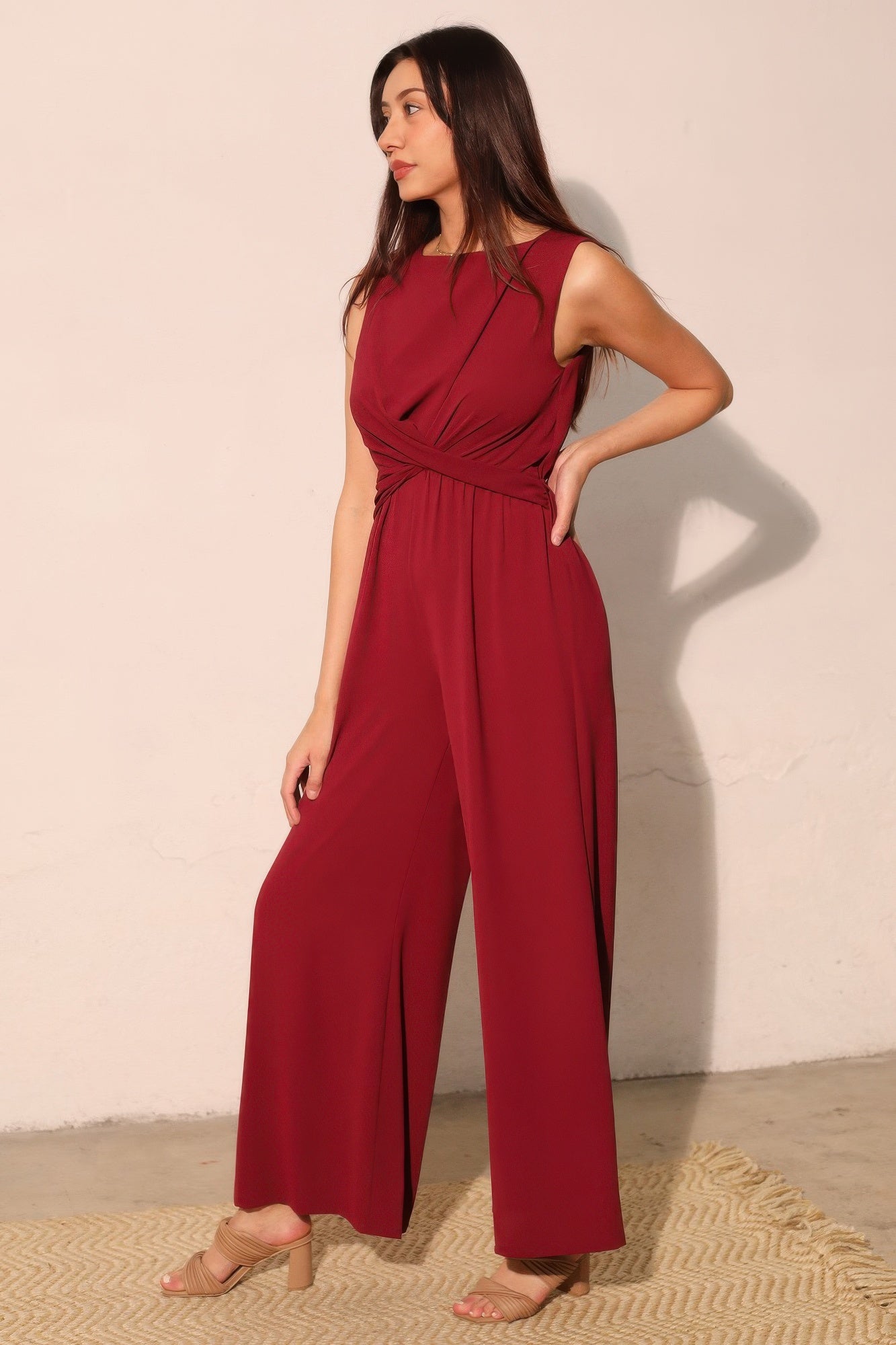 Wine-red twist-front jumpsuit, sleeveless with draped waist