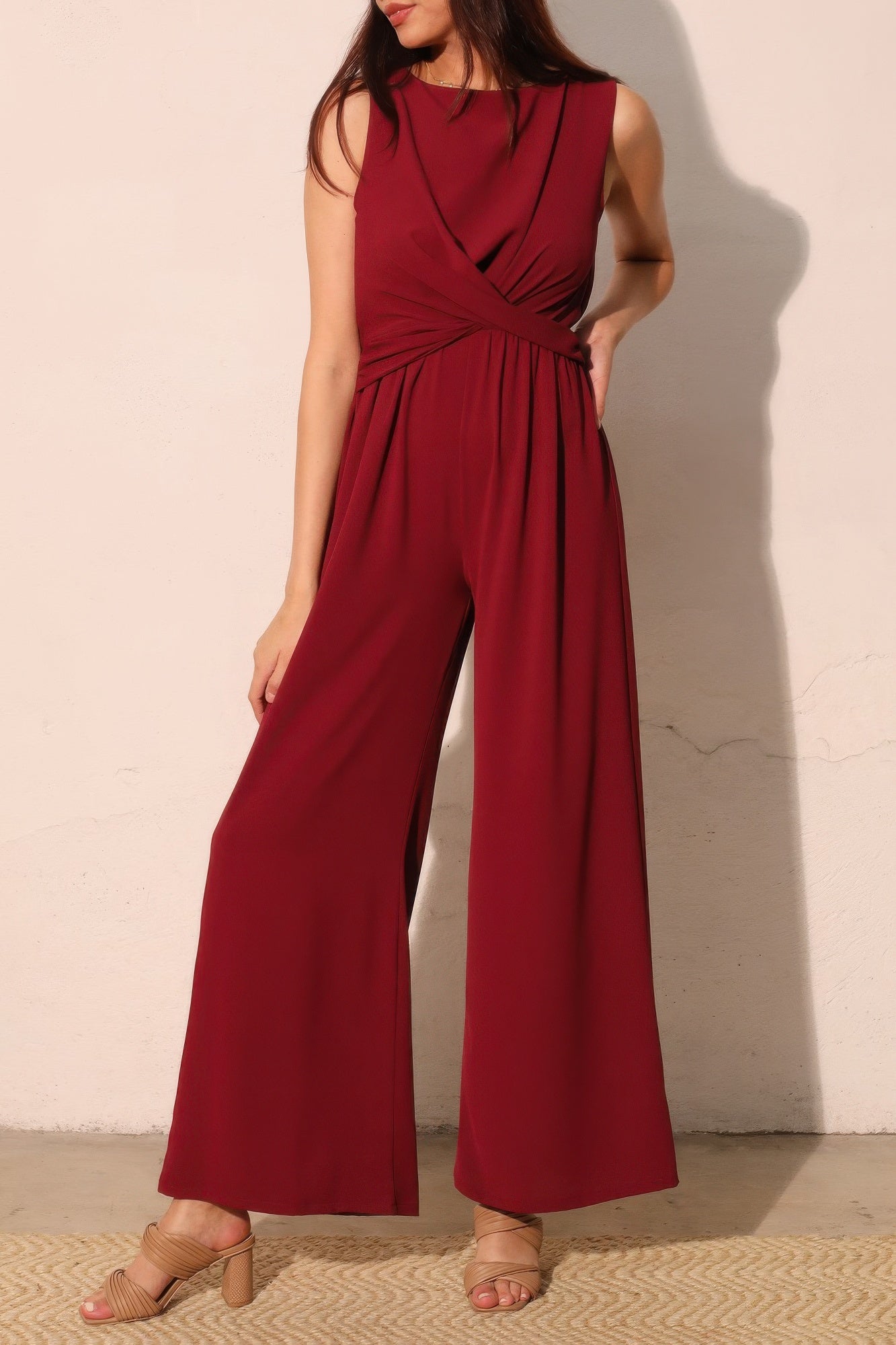 Wine-red sleeveless jumpsuit with twist waist and wide pant legs