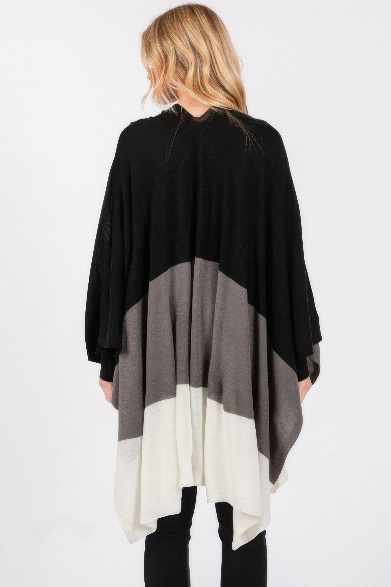 Back view of three-tone ruana: black top with gray and white panels; draped design.