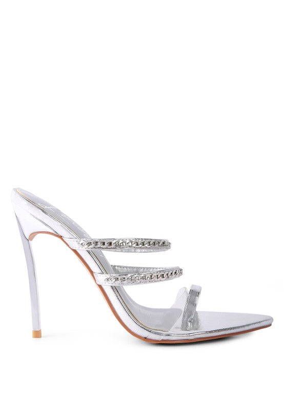 Silver high-heeled mule sandals with toe ring, clear side strap, and chain trim