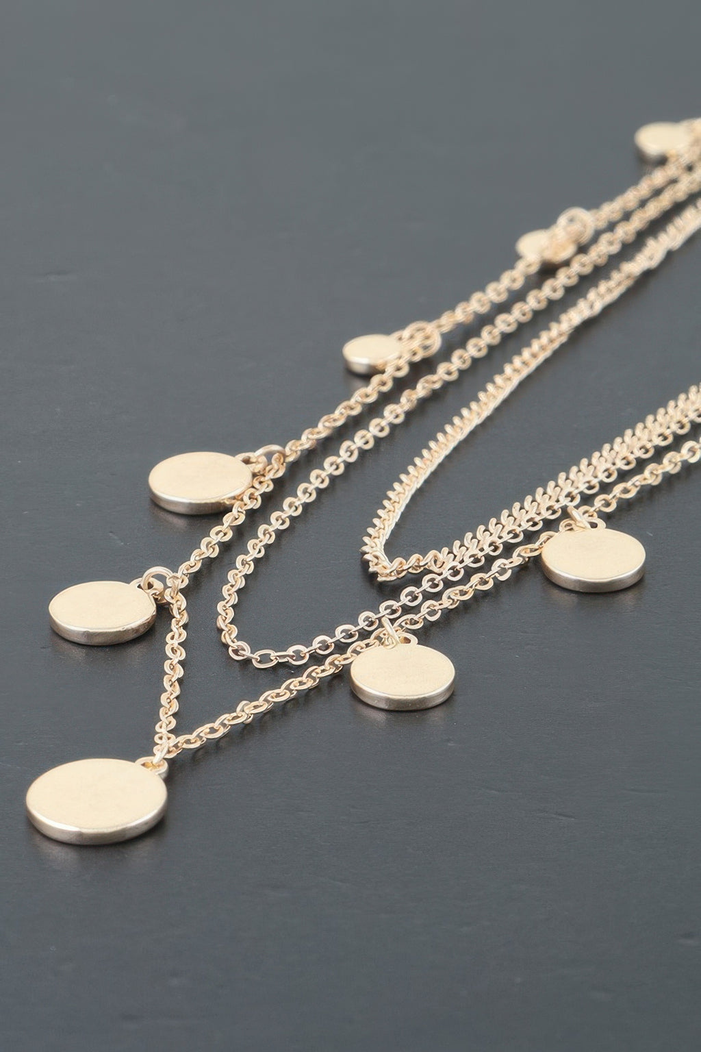 Gold-tone triple chain necklace with round disc charms on overlapping chain rows