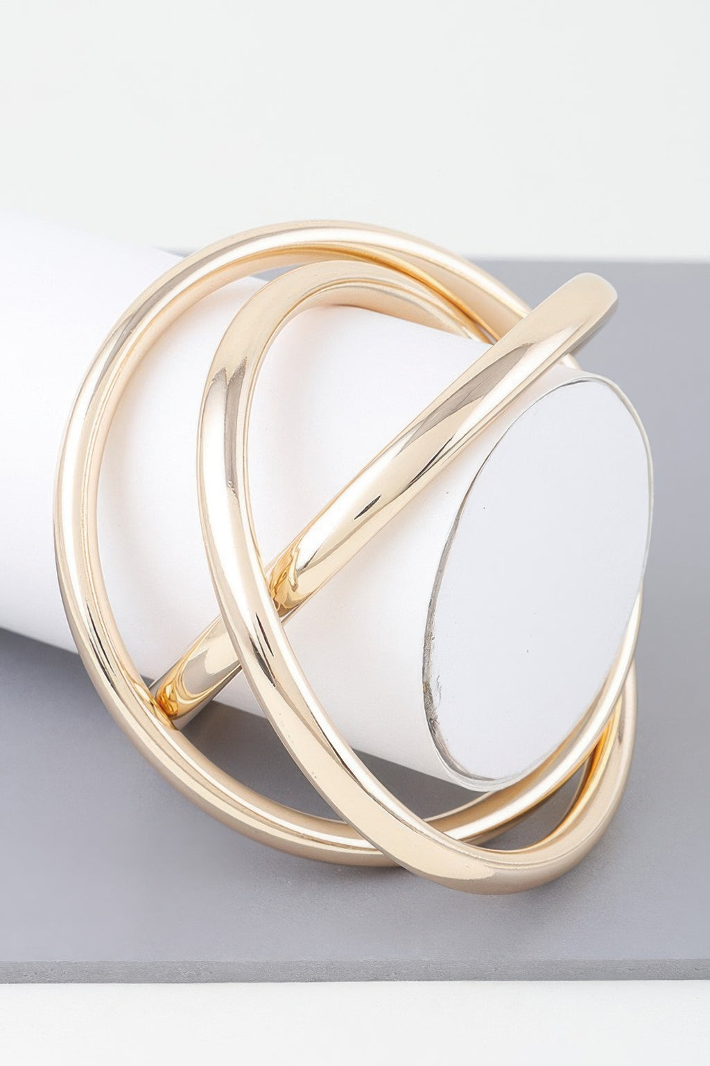 Triple shiny gold bangle bracelet with three overlapping curved bands