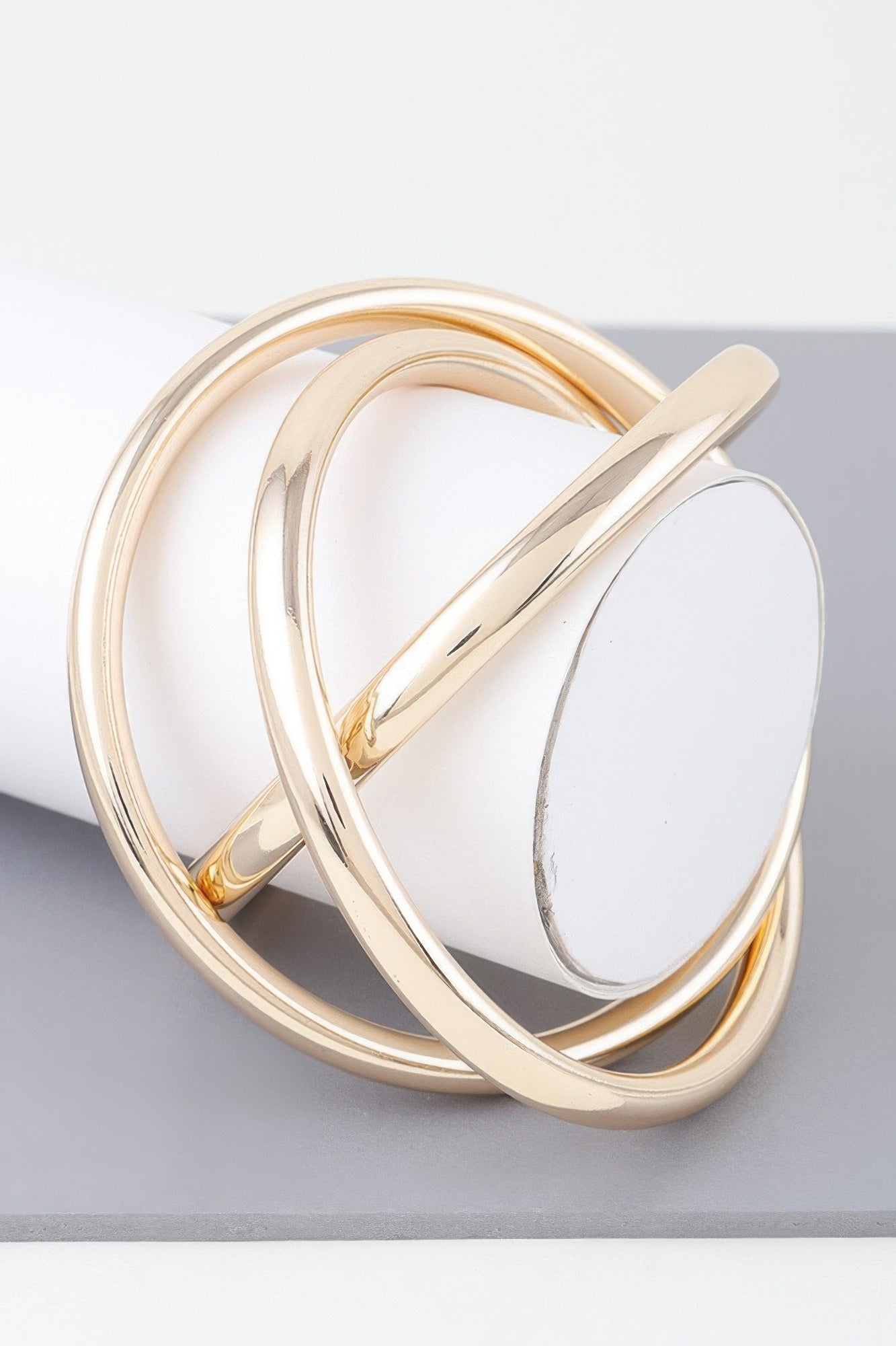 Triple shiny gold bangle bracelet with three overlapping curved bands