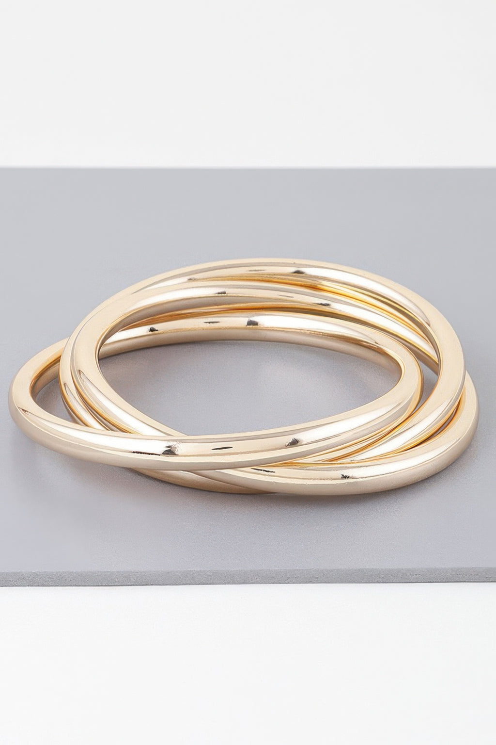 Gold triple bangle bracelet with three polished circular loops