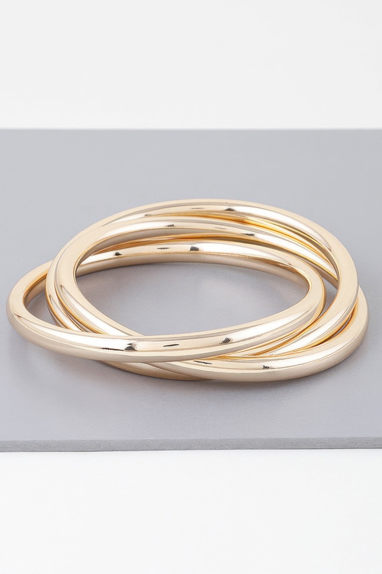 Gold triple bangle bracelet with three polished circular loops