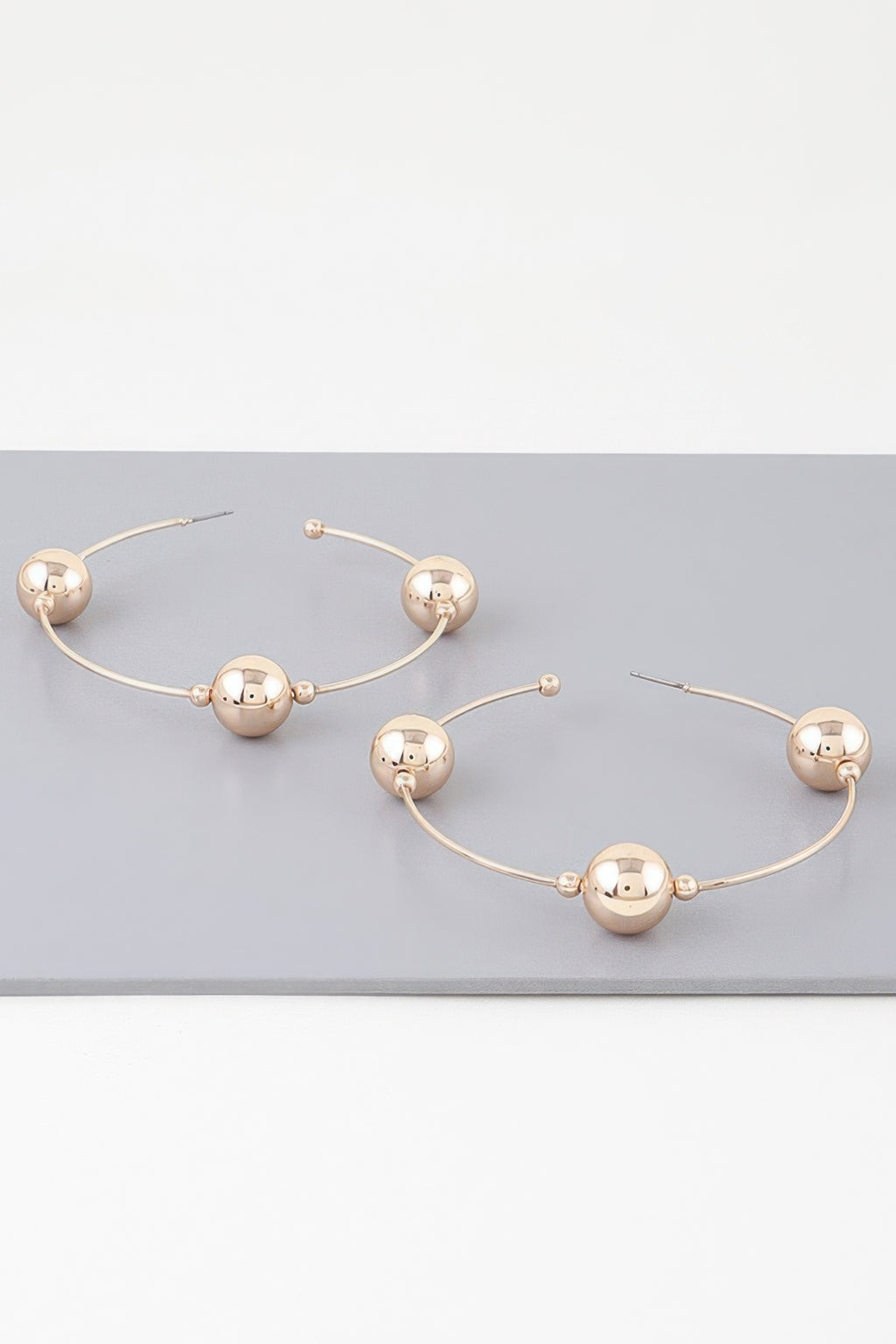 Triple shiny bead hoop earrings in gold-tone, three round beads on slim hoops