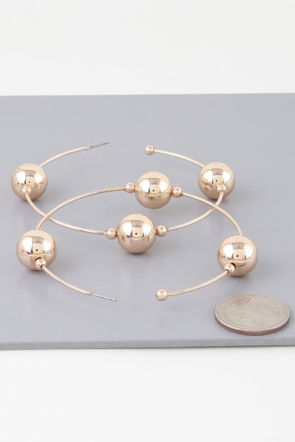 Gold-tone triple bead hoop earrings with three mirrored spheres on curved wires
