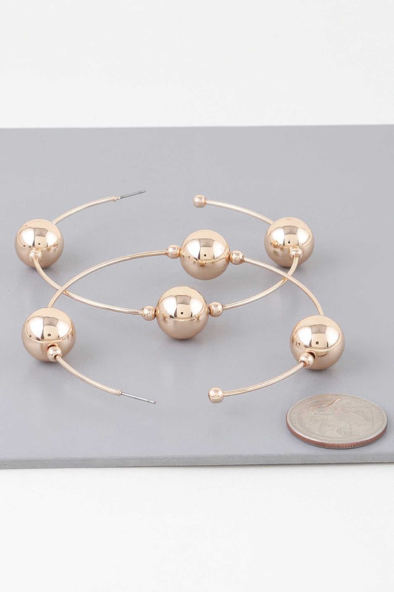 Gold-tone triple bead hoop earrings with three mirrored spheres on curved wires